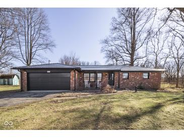 Charming single-story brick home featuring an attached garage and a well-maintained front yard at 7089 W Us Highway 36, Danville, IN 46122