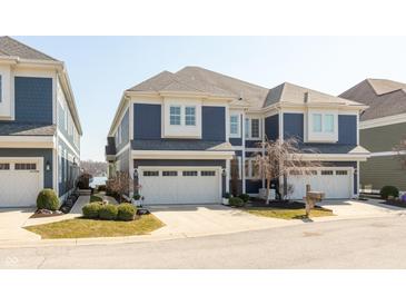 Beautifully maintained multi-story home featuring a three-car garage and attractive blue siding at 12561 Marina View Dr, Indianapolis, IN 46256