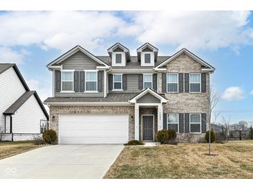 Charming two-story home with brick and vinyl siding, a well-manicured lawn, and an attached two-car garage at 16406 Taconite Dr, Noblesville, IN 46060