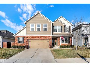Inviting two-story home featuring a brick facade, siding, attached garage, and well-maintained landscaping at 16736 Workington Way, Westfield, IN 46074