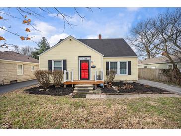 Charming yellow home featuring a red front door and well-kept landscaping at 1711 Kessler E Blvd, Indianapolis, IN 46220
