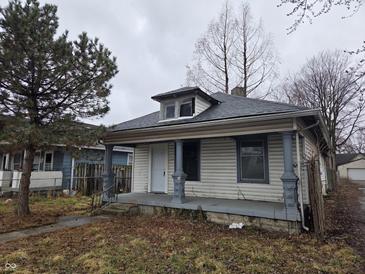 Modest home featuring gray trim on the porch and siding, under an overcast sky at 238 S Temple Ave, Indianapolis, IN 46201