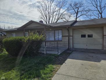 Cozy single-story home featuring a charming front porch and attached one-car garage at 3044 Manor Ct, Indianapolis, IN 46218