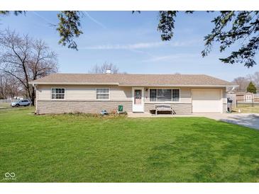 Charming single-story home with a well-manicured lawn, a bench, and an attached garage, perfect for easy living at 348 W Stop 11 Rd, Indianapolis, IN 46217