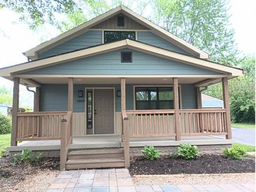 Charming home featuring a covered front porch, blue siding, and manicured landscaping at 5603 S Randolph St, Indianapolis, IN 46227