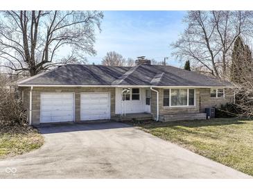 Charming single-story home featuring a two-car garage and a well-maintained front lawn at 7401 E 56Th St, Indianapolis, IN 46226