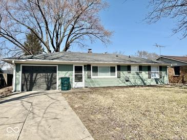 Charming ranch-style home featuring a cozy facade, attached garage, and well-maintained lawn at 2308 W Surrey Dr, Muncie, IN 47304