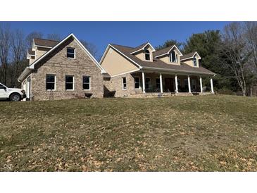 Expansive two-story home featuring a brick facade, inviting front porch, and well-manicured lawn at 3040 Old Morgantown Rd, Martinsville, IN 46151