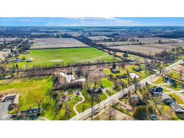 Expansive aerial view of the property showing the surrounding farmland, ponds, and neighborhood at 905 S Maple St, Fortville, IN 46040