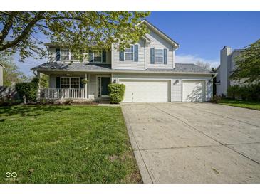 Charming two-story home featuring a welcoming porch and a three car attached garage at 11458 Falling Water Way, Fishers, IN 46037