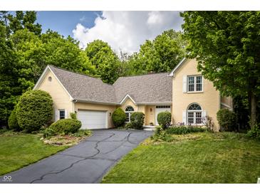 Charming yellow brick home with lush green landscaping and an inviting driveway at 12348 Seaway Cir, Indianapolis, IN 46236