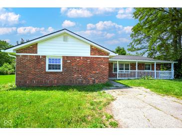 Charming brick home with a covered front porch, grassy yard, and sunny sky at 1509 E Centennial Ave, Muncie, IN 47303