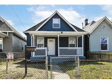 Charming home featuring a covered porch, white trim, and a quaint front yard, offering curb appeal at 1521 Lawton Ave, Indianapolis, IN 46203
