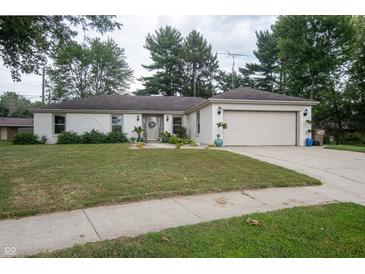 Charming single-story home with a well-manicured lawn, attached garage, and inviting curb appeal at 3335 Woodcrest Ct, Columbus, IN 47203