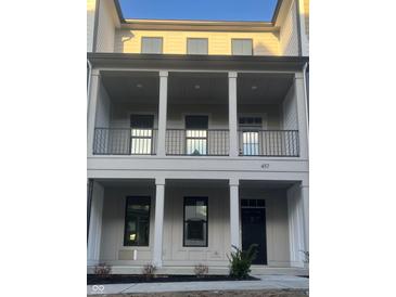 Beautiful multi-level townhome showcases stacked balconies with gray siding and complementary black accents at 457 Mariposa Trl, Carmel, IN 46032