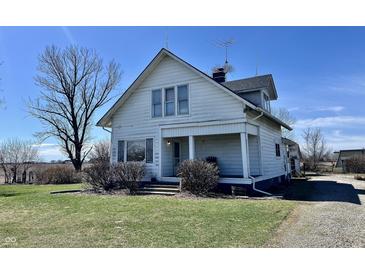 Charming two-story home with covered porch and mature landscaping sits under a clear blue sky at 810 S 400 W, Bargersville, IN 46106