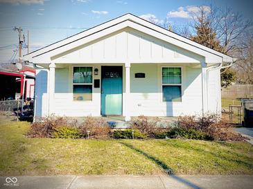 Charming one-story home with a tidy yard, front porch and an inviting turquoise-colored front door at 1133 S Kealing Ave, Indianapolis, IN 46203