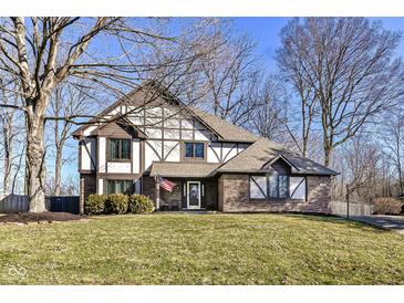 Charming Tudor-style home with a well-manicured lawn and a welcoming front entrance at 1728 Timber Heights Dr, Carmel, IN 46280