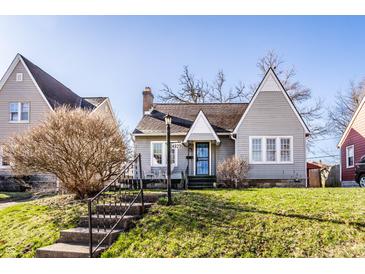 Charming home featuring a manicured lawn, tidy landscaping, and a cozy front porch sitting area at 4929 Young Ave, Indianapolis, IN 46201