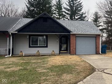 Charming single-story home with a tidy front yard and an attached one-car garage, nestled among mature trees at 5212 Mason Cir, Indianapolis, IN 46254