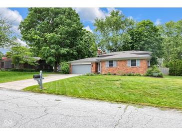 Charming brick home with a well-manicured lawn and mature trees at 629 Williamsburg Ln, Greenwood, IN 46142
