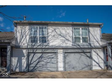 Two-story home featuring a garage, white siding, and double-paned windows at 7837 Hunters Path, Indianapolis, IN 46214