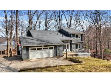 Charming two-story home with stone accents, a two-car garage, and a deck overlooking a tree-filled yard at 7899 S Timber Cliff Ln, Trafalgar, IN 46181