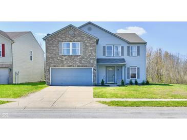 Charming two-story home with a brick facade, attached garage, and well-maintained landscaping at 8630 Aylesworth Dr, Camby, IN 46113