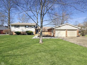 A two story home featuring a lush green lawn, mature trees, and detached garage at 3736 W South Wood Lake Dr, Columbus, IN 47201