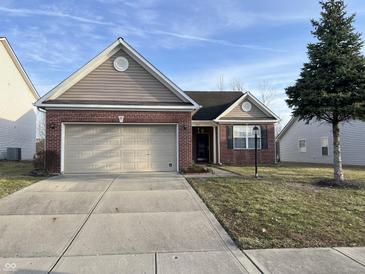 Charming single-Gathering home boasts brick accents, a two-car garage, and a well-maintained front lawn at 5832 Cabot Dr, Indianapolis, IN 46221