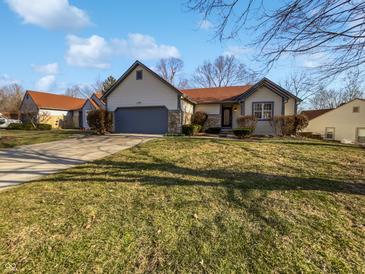 Charming single-story home featuring a well-manicured front yard and attached garage, with blue sky at 6232 Behner Xing, Indianapolis, IN 46250