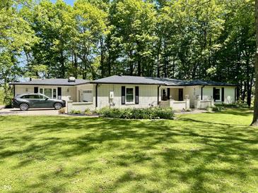 Charming brick home features a lush lawn, flowerbeds, and a convenient attached garage at 2408 E Stafford Pl, Martinsville, IN 46151