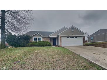 Charming one-story home featuring a well-maintained lawn, attached two-car garage, and welcoming entrance at 2617 N Temple Ave, Indianapolis, IN 46218