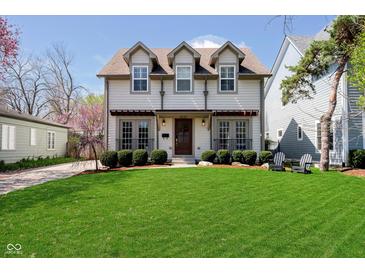 Charming two-story home with a well-manicured lawn and a welcoming front porch, perfect for relaxing outdoors at 5032 N Illinois St, Indianapolis, IN 46208
