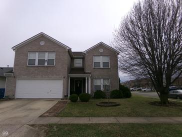 Charming two-story brick home featuring an attached garage and well-maintained front yard at 6651 Sonesta Dr, Indianapolis, IN 46217