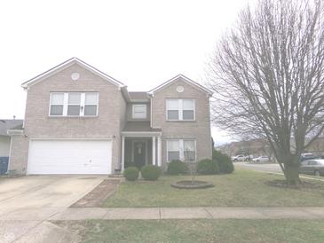 Charming two-story brick home with a manicured lawn and attached garage at 6651 Sonesta Dr, Indianapolis, IN 46217