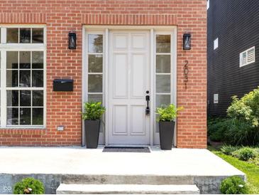 Charming brick home featuring a front door with sidelights and decorative plants at 2031 Central Ave, Indianapolis, IN 46202