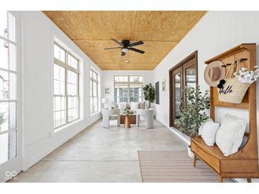 Bright sunroom with large windows, comfortable seating, and a decorative ceiling fan at 2031 Central Ave, Indianapolis, IN 46202