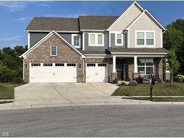Charming two-story home boasts a brick and siding exterior, three-car garage and a welcoming front porch at 3535 Merchmont Rd, Bargersville, IN 46106