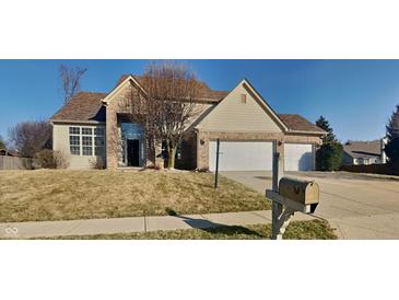 Inviting two-story home with a two car garage and manicured front lawn and brick accents under a clear sky at 11144 Echo Trl, Indianapolis, IN 46236