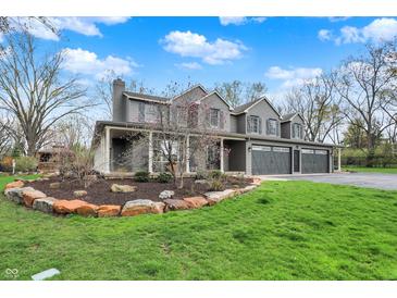 Stunning two-story home featuring a three-car garage, covered porch, and professionally landscaped front yard at 11796 Sycamore St, Zionsville, IN 46077