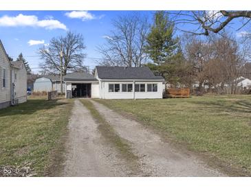 Charming single-story home with a spacious yard, garage, and a quaint wooden deck at 3018 Alice Ave, Indianapolis, IN 46237