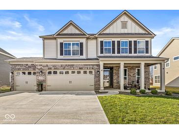 Charming two-story home featuring a brick and siding facade, a three-car garage, and a welcoming front porch at 4179 Ironclad Dr, Bargersville, IN 46106