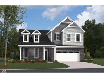Charming two-story home showcasing a mix of stone and siding, complemented by dormer windows and a two-car garage at 5715 Cloister Ln, McCordsville, IN 46055