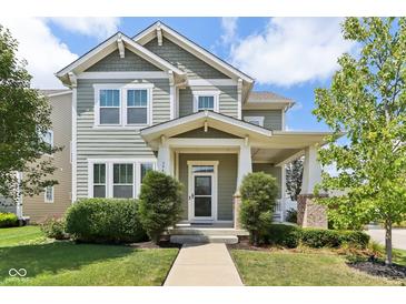 Charming two-story home with a covered porch and landscaped front yard and green horizontal siding at 5944 Aldridge Dr, Whitestown, IN 46075