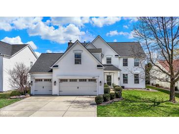 Charming two-story home featuring a three-car garage, manicured lawn, and classic white siding at 6571 Hunters S Rdg, Zionsville, IN 46077