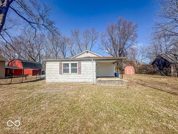 Charming single-story home with a covered porch and mature trees under a beautiful blue sky at 6616 W Thompson Rd, Indianapolis, IN 46241