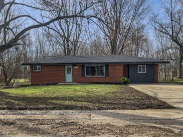 Charming single story home with a brick facade, blue door, and large front yard at 110 Pleasant Run Dr, Markleville, IN 46056