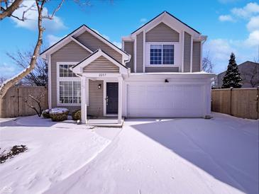 Two-story home features a covered entry, two-car garage, and snow-covered front yard on a sunny winter day at 2257 Grand Fir Dr, Greenwood, IN 46143