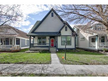 Charming two-story home with a covered porch, landscaped yard, and a vibrant red front door at 2432 N Talbott St, Indianapolis, IN 46205